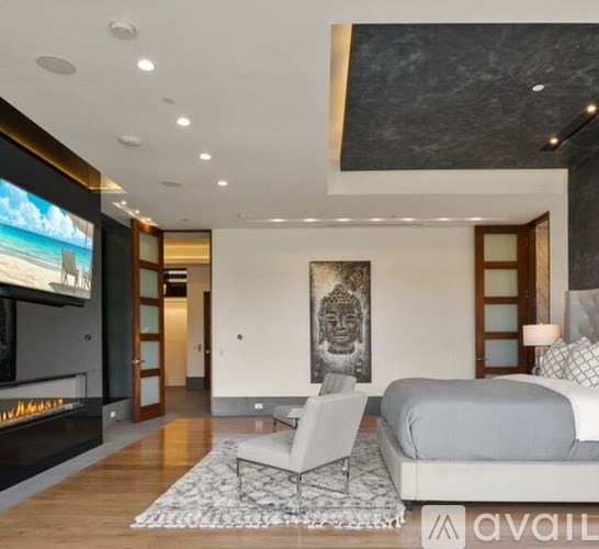 A modern living room with a fireplace and a large screen TV.