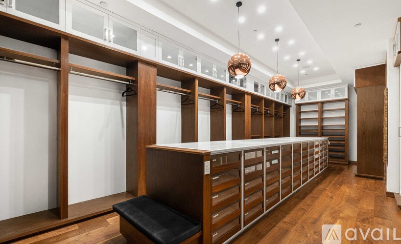 A row of wooden lockers with glass doors are lined up in a room.