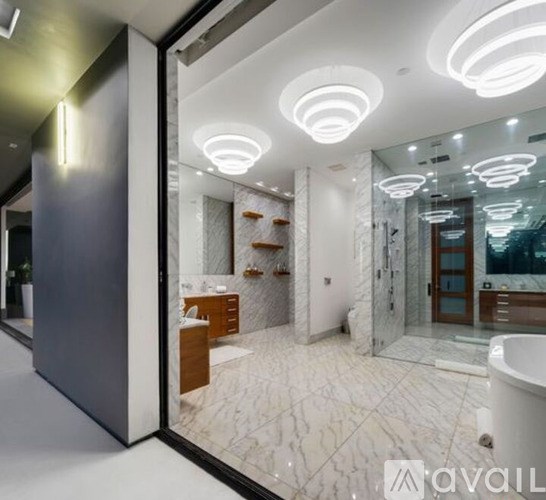 A bathroom with a marble floor and a large mirror.