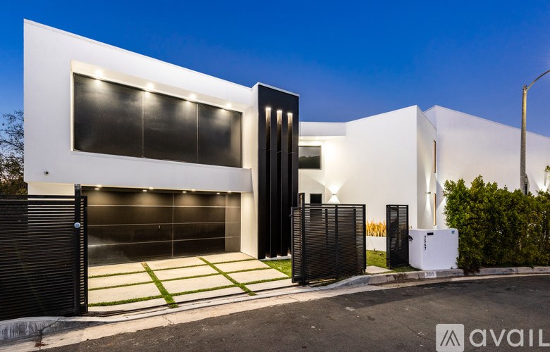 A modern house with a black gate and a white exterior.