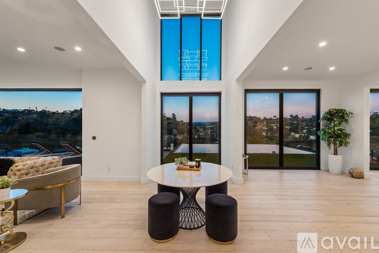 A modern living room with a large window overlooking a landscape.