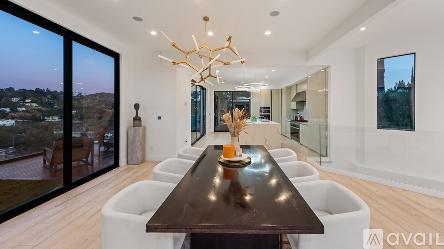 A modern dining room with a long table and chairs.