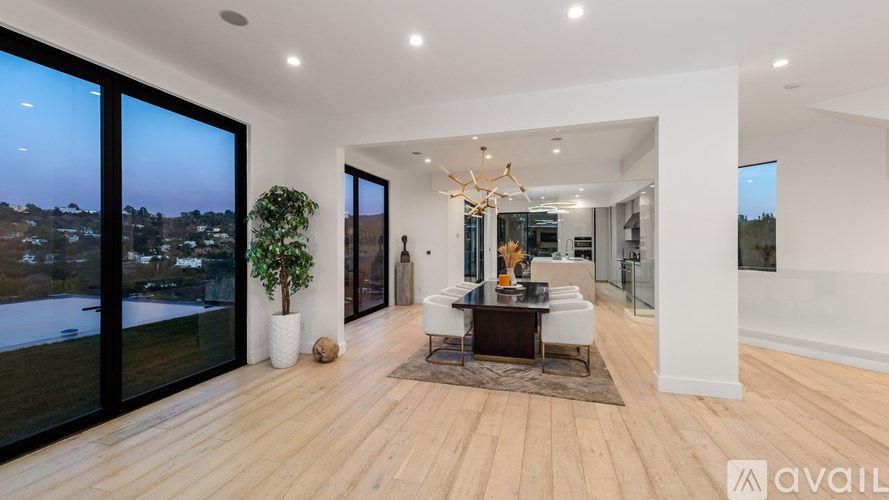 A modern living room with a view of the city at dusk.
