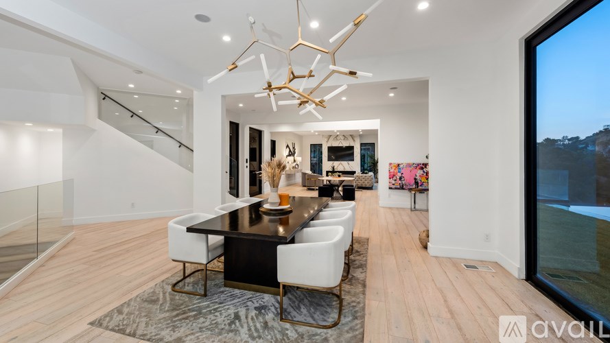 A modern dining room with a glass table and chairs.