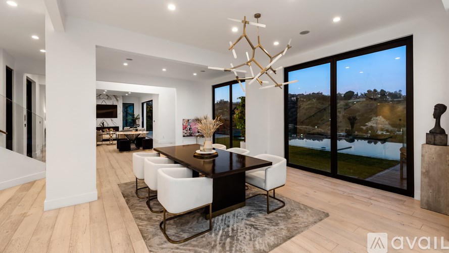 A modern dining room with a wooden table and chairs.
