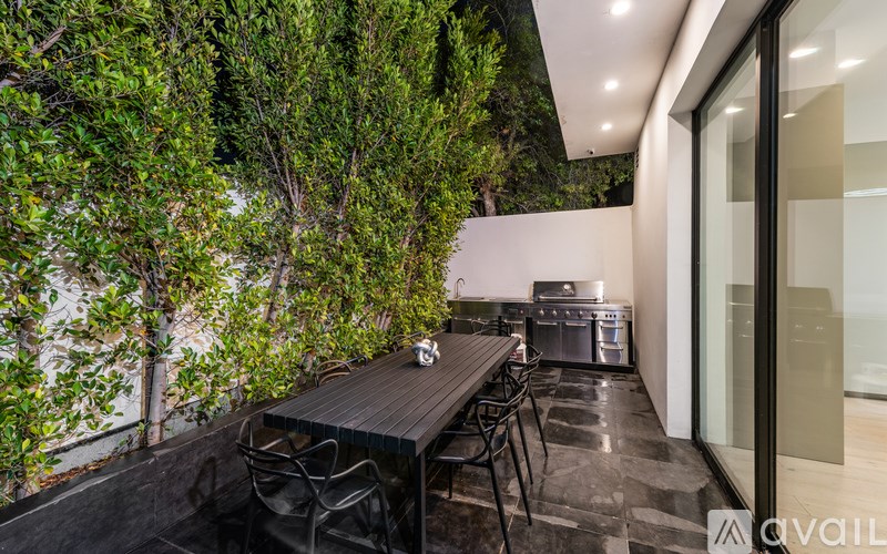 A modern outdoor dining area with a table set for four.