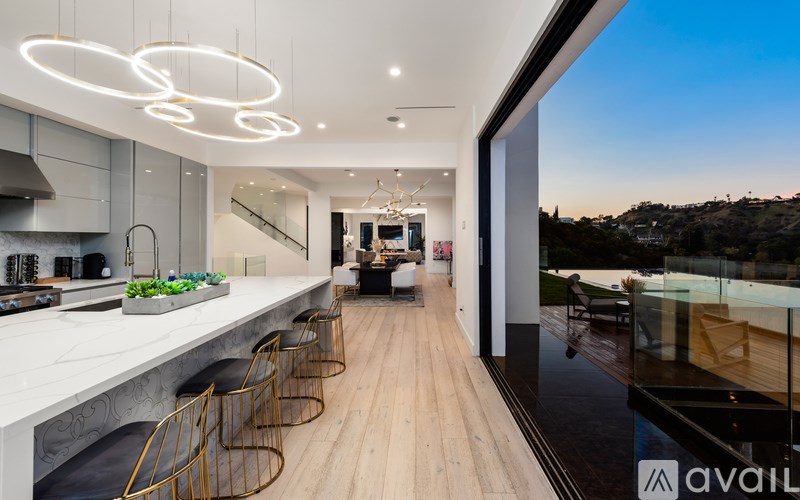 A modern kitchen with a long counter and bar stools.