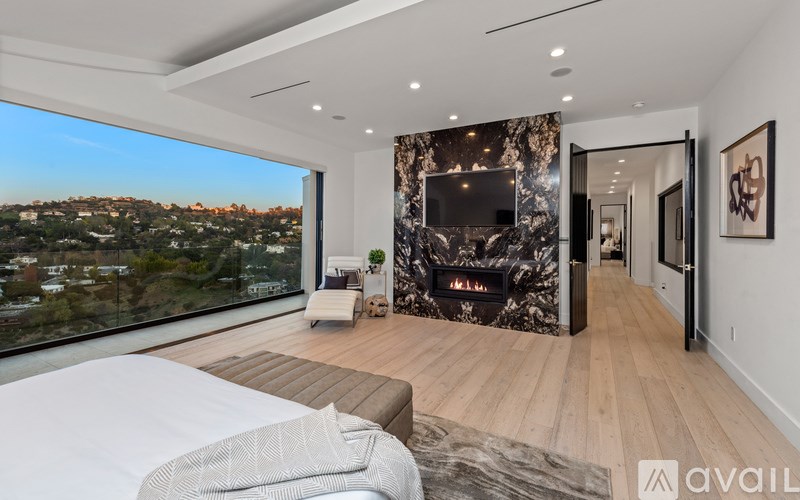 A modern bedroom with a large bed and a view of the city.