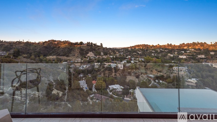 A view from a high vantage point looking down at a town with a glass barrier in the foreground.