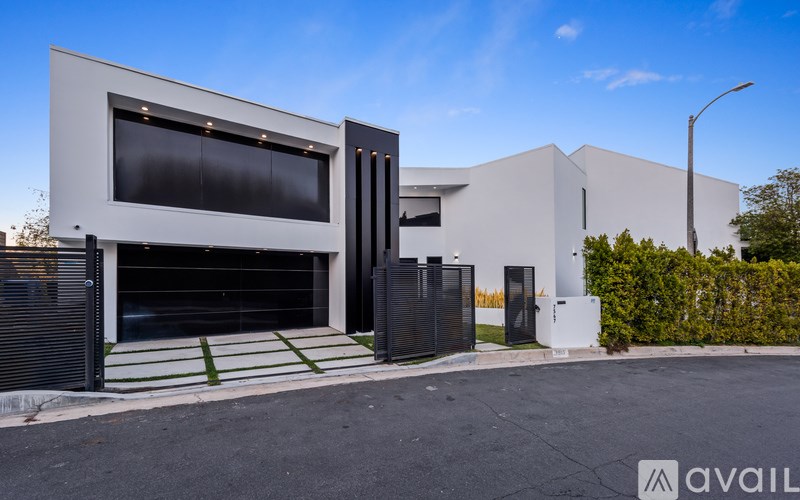 A modern house with a black and white exterior and a large garage door.