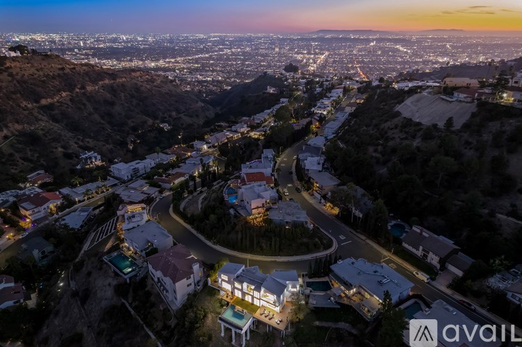 A beautiful aerial view of a city at dusk with a house in the foreground.