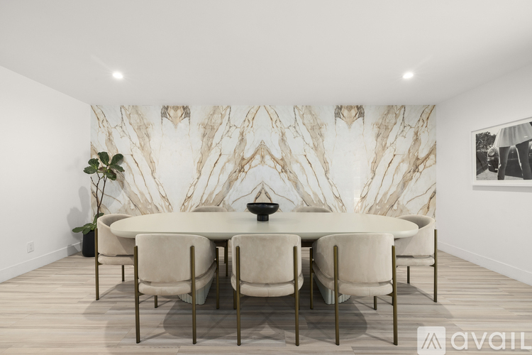 A dining room with a white table and chairs.