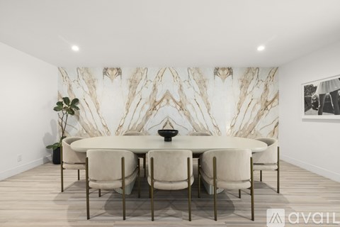 A dining room with a white table and chairs.