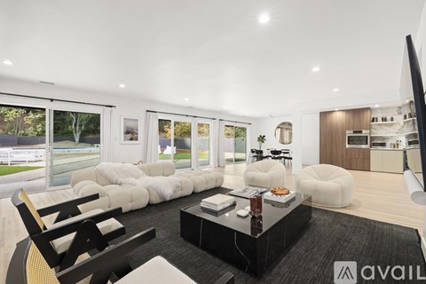 A modern living room with a black coffee table and white furniture.