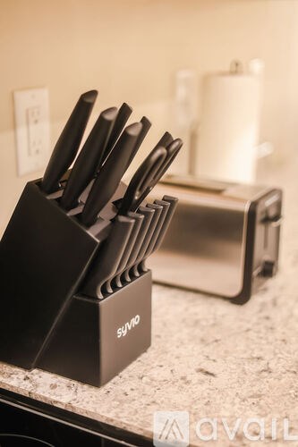 A set of knives is placed in a black knife block.