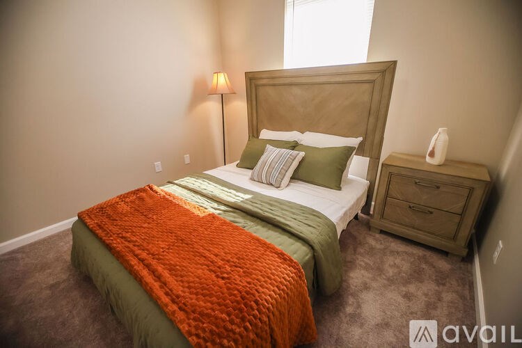 A bedroom with a bed, nightstand, and lamp.