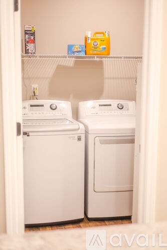 Two white front loading washing machines in a small laundry room.