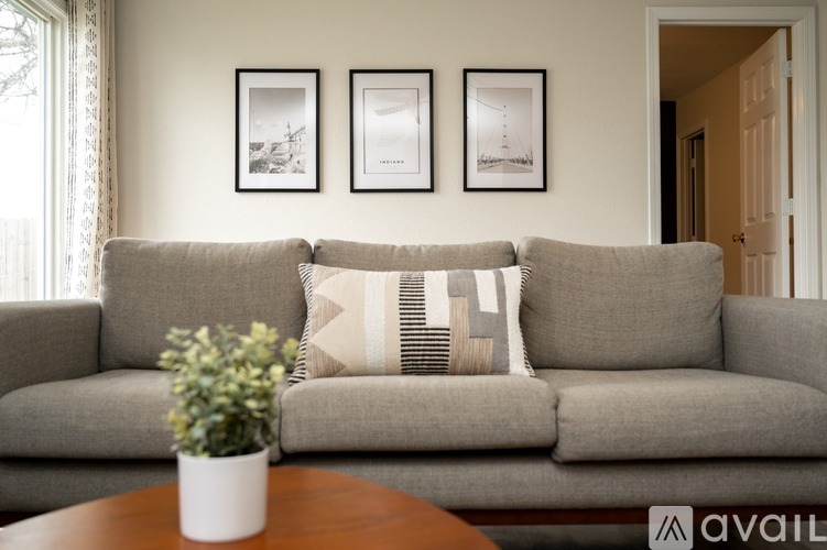 A bedroom with a bed, nightstand, and pictures on the wall.