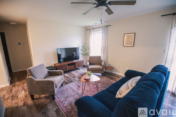 A bedroom with a bed, a ceiling fan, and a nightstand.