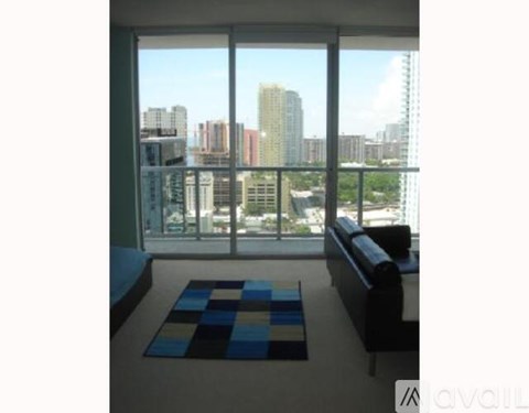 A living room with a couch and a view of the city.