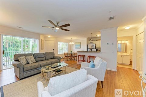 A living room with a grey couch and a white chair.