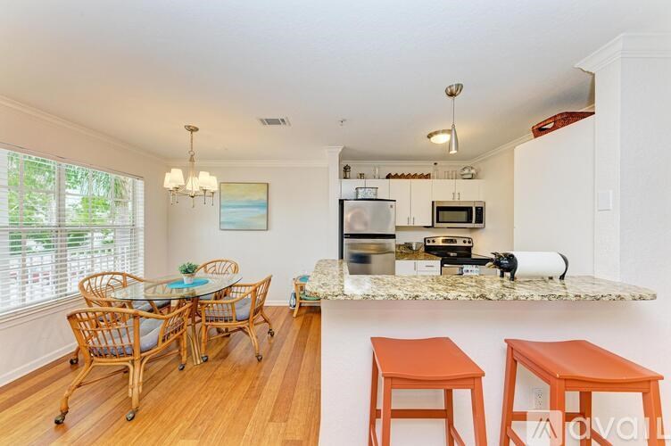 A kitchen with a table and chairs in front of a window.