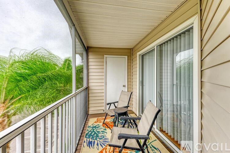 A balcony with chairs and a table is shown.