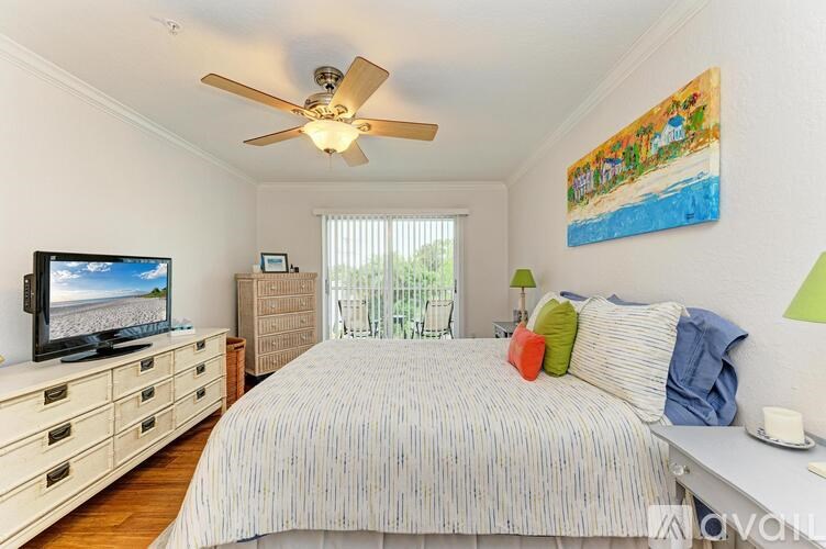 A bedroom with a bed, a television, and a painting on the wall.
