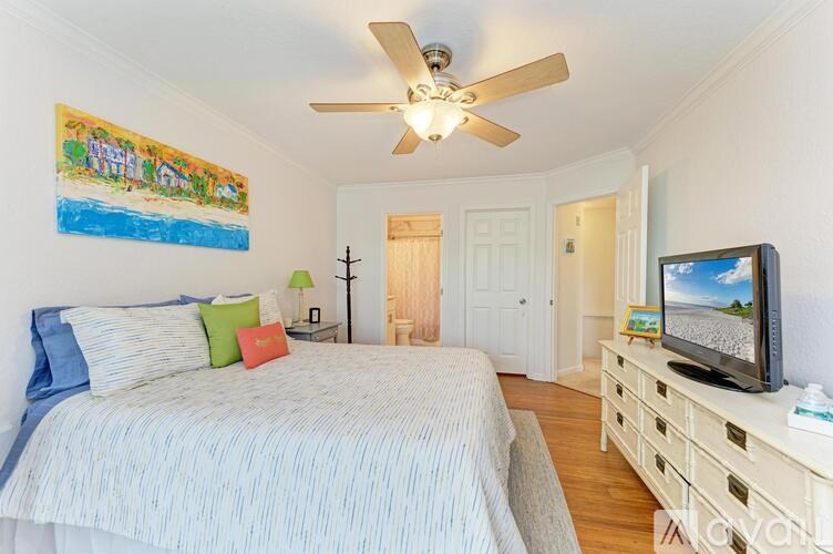 A bedroom with a bed, a television, and a painting on the wall.