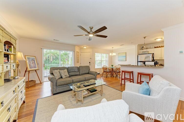 A living room with a grey couch, a white chair, and a wooden coffee table.