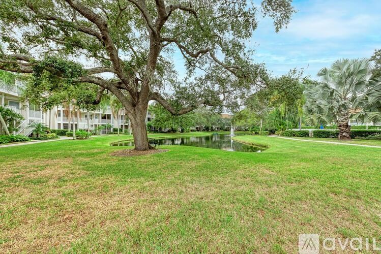 A large tree in a grassy area with a house in the background.