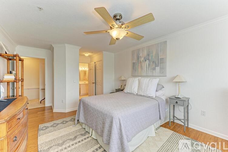 A bedroom with a bed, nightstand, and a ceiling fan.