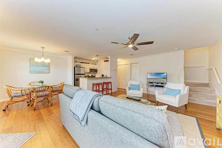 A living room with a grey couch and a wooden floor.