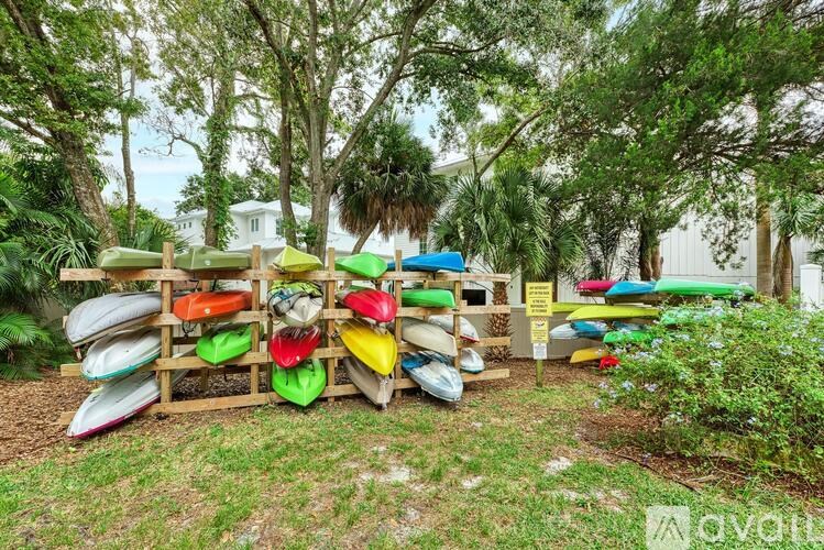 A row of kayaks are lined up on a rack.