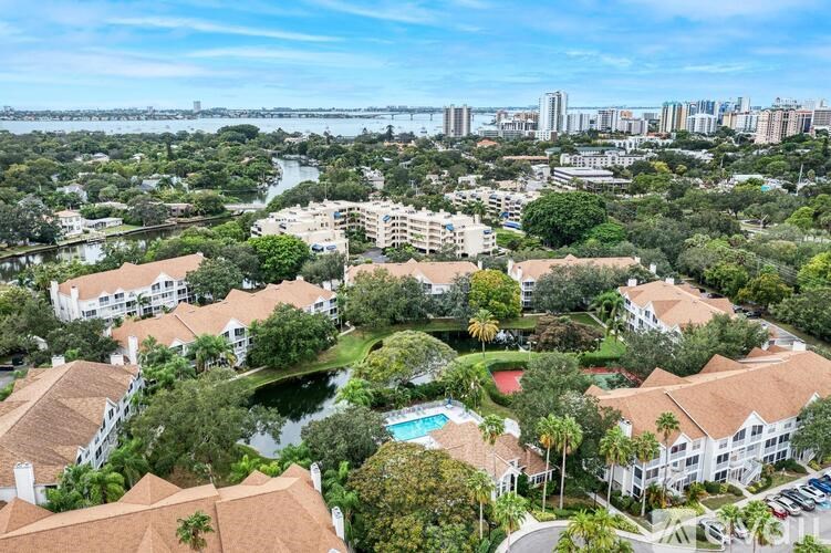 A bird's eye view of a resort with a pool and palm trees.
