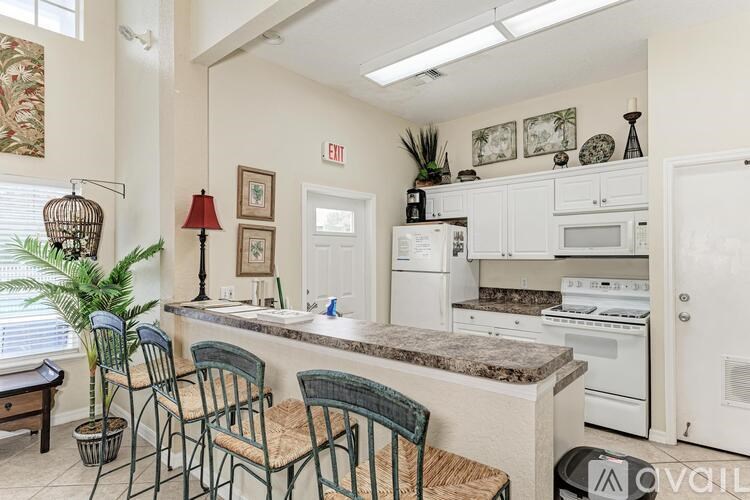 A kitchen with a table and chairs and a fridge.