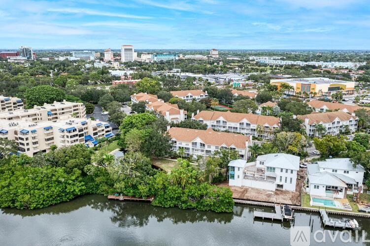 A bird's eye view of a residential area with a body of water in the foreground.