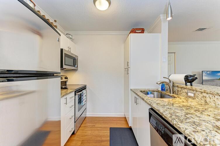 A kitchen with granite countertops and white cabinets.