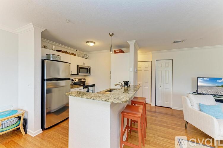 A kitchen with a refrigerator, microwave, and oven.