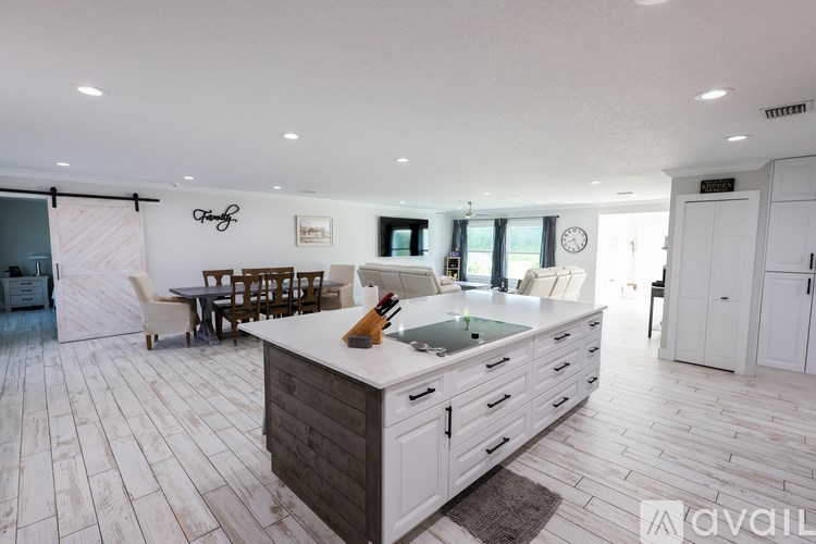A modern kitchen with white cabinets and a wooden island.
