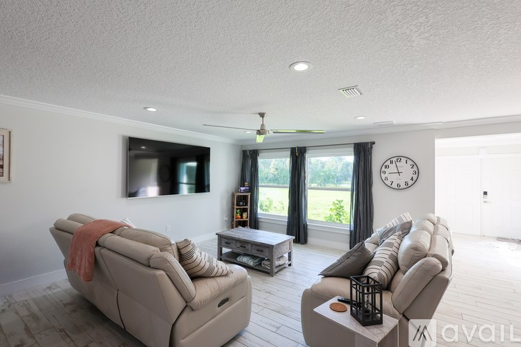 A living room with two couches and a television mounted on the wall.