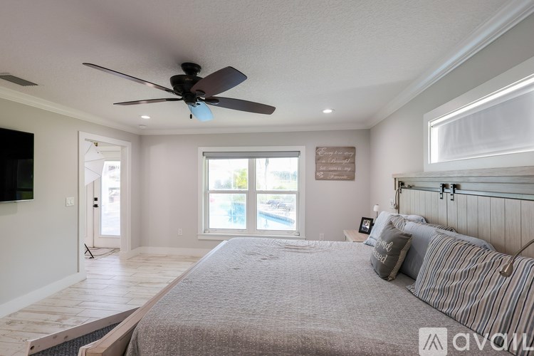 A bedroom with a large bed and a ceiling fan.
