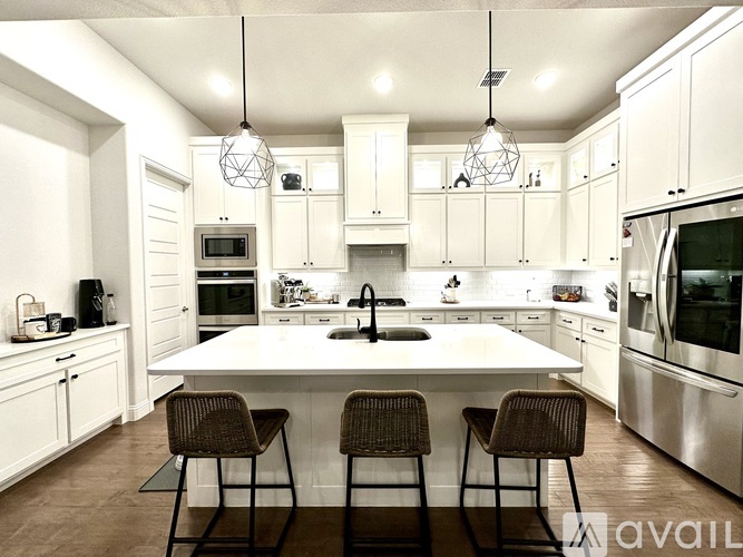 A modern kitchen with white cabinets and a central island.