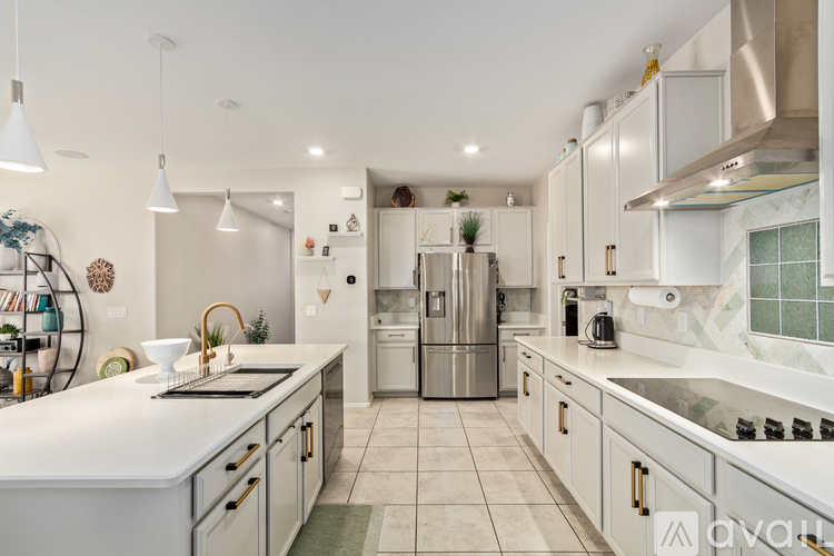 A modern kitchen with white cabinets and a central island.