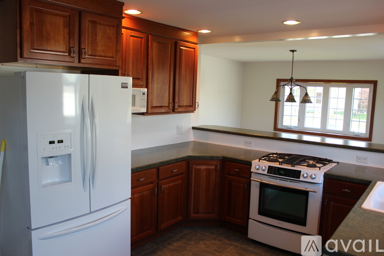A kitchen with a white refrigerator and a stove top oven.