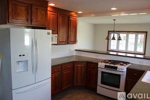 A kitchen with a white refrigerator and a stove top oven.