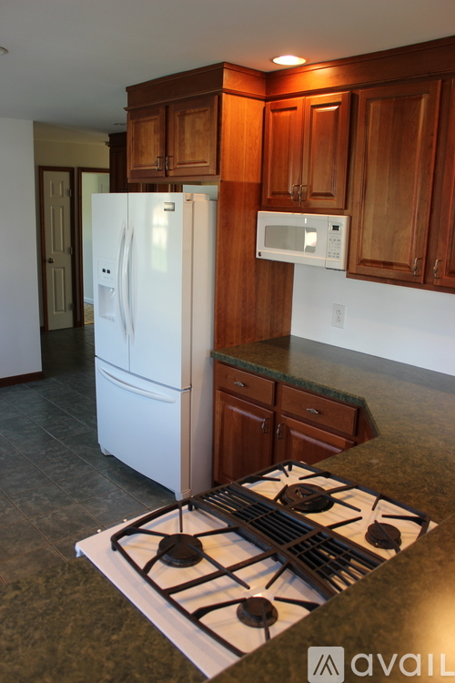 A kitchen with a white fridge and a white stove top.