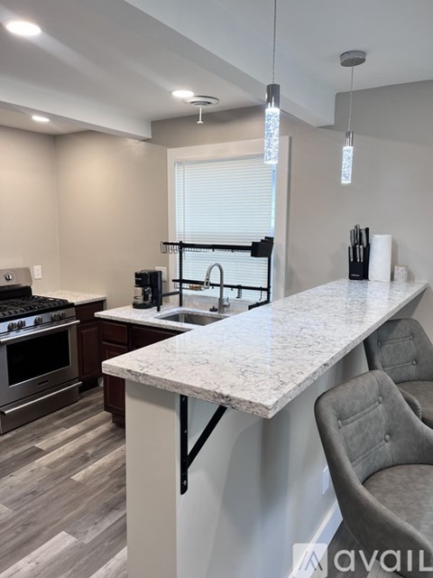A kitchen with a marble countertop and a bar stool.
