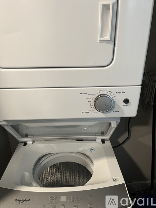 A white Whirlpool dryer is on a grey surface.