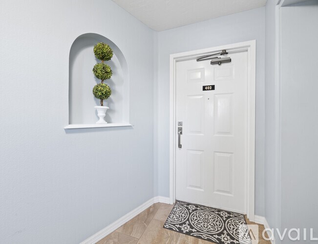 A white door with a black doorknob and a number 102 on the top right corner.